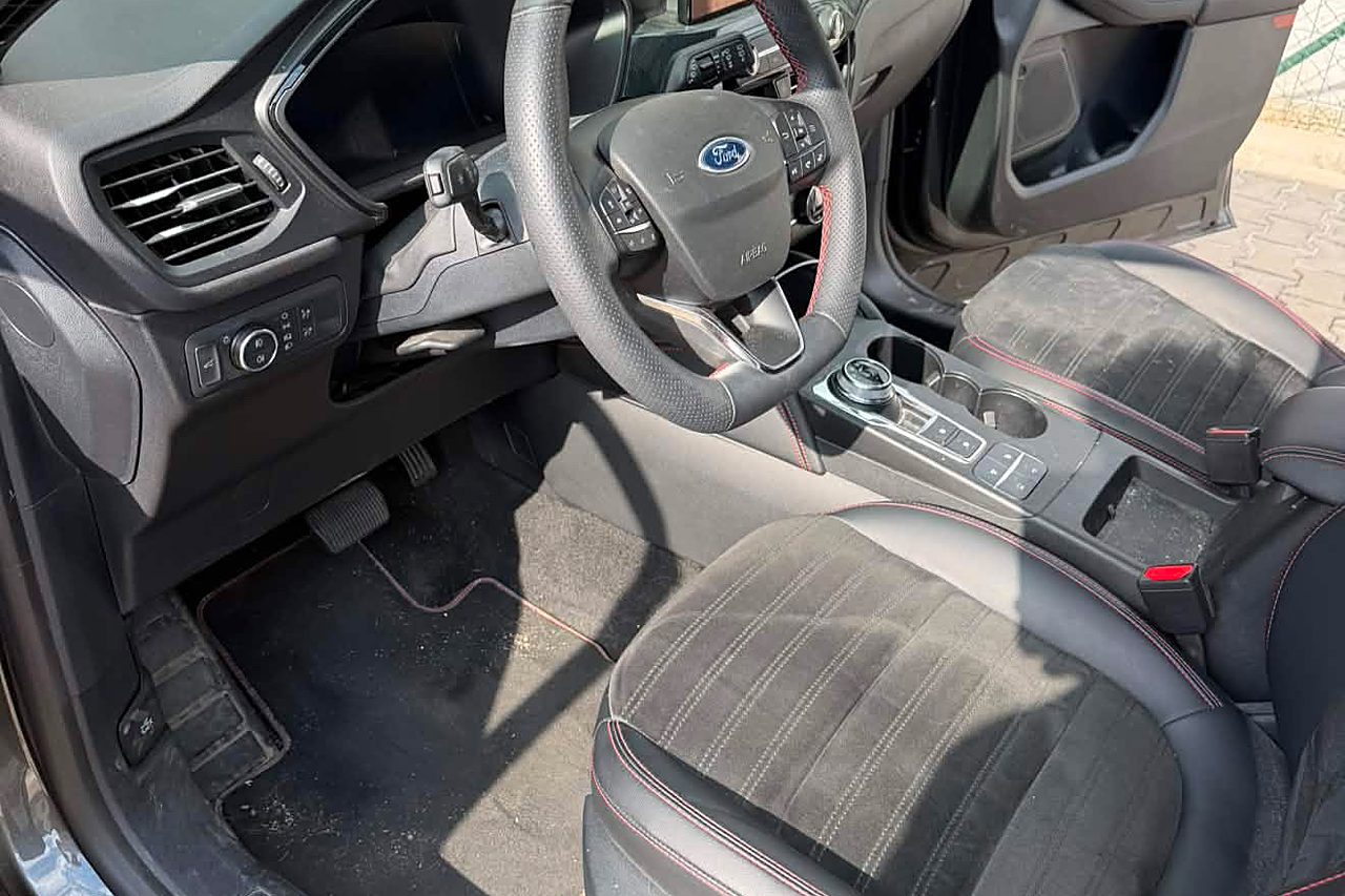 Místo řidiče před detailingem: prach a zašlé koberečky